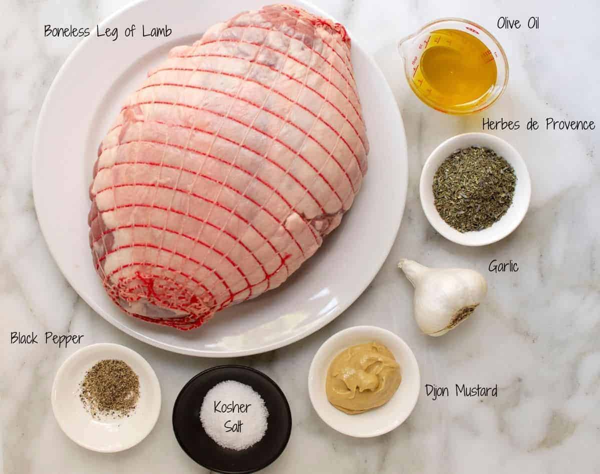 Roasted Boneless Leg of Lamb Ingredients on a white marble board