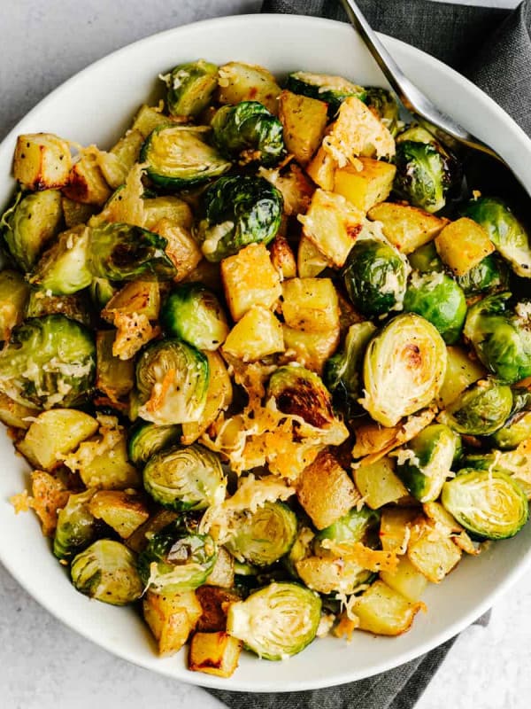 Roasted Potatoes and Brussels Sprouts served in a white bowl and photographed from above.