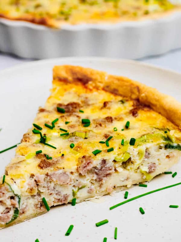 Sausage Quiche wedge served on a ceramic plate.