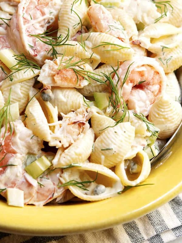 seafood pasta salad served in a yellow ceramic bowl