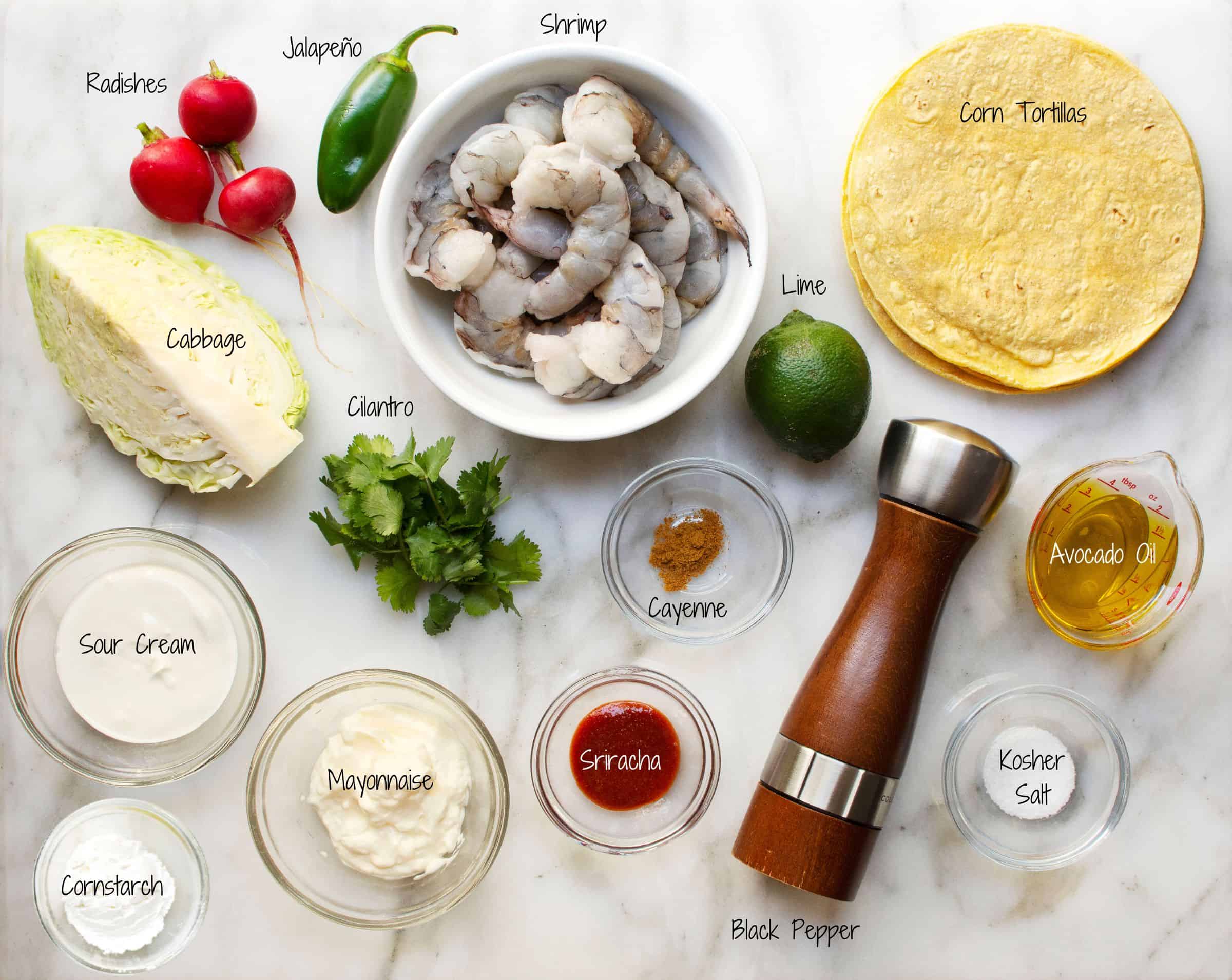 Shrimp Tacos Ingredients arranged on a white marble board.