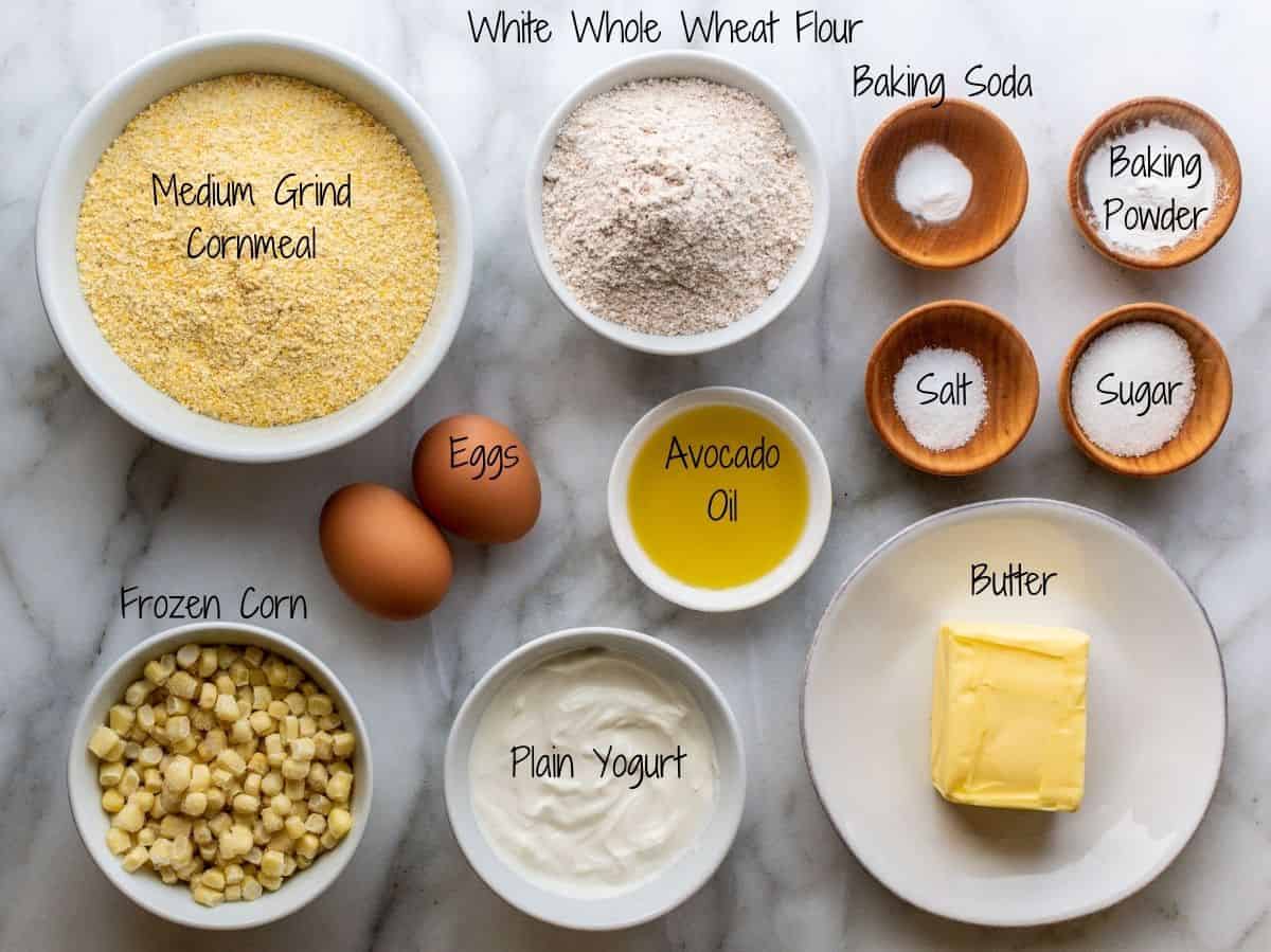 Skillet Cornbread Ingredients with Plain Yogurt on a white marble board.