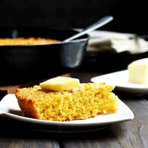 Skillet-Cornbread-served-with-butter on a white plate