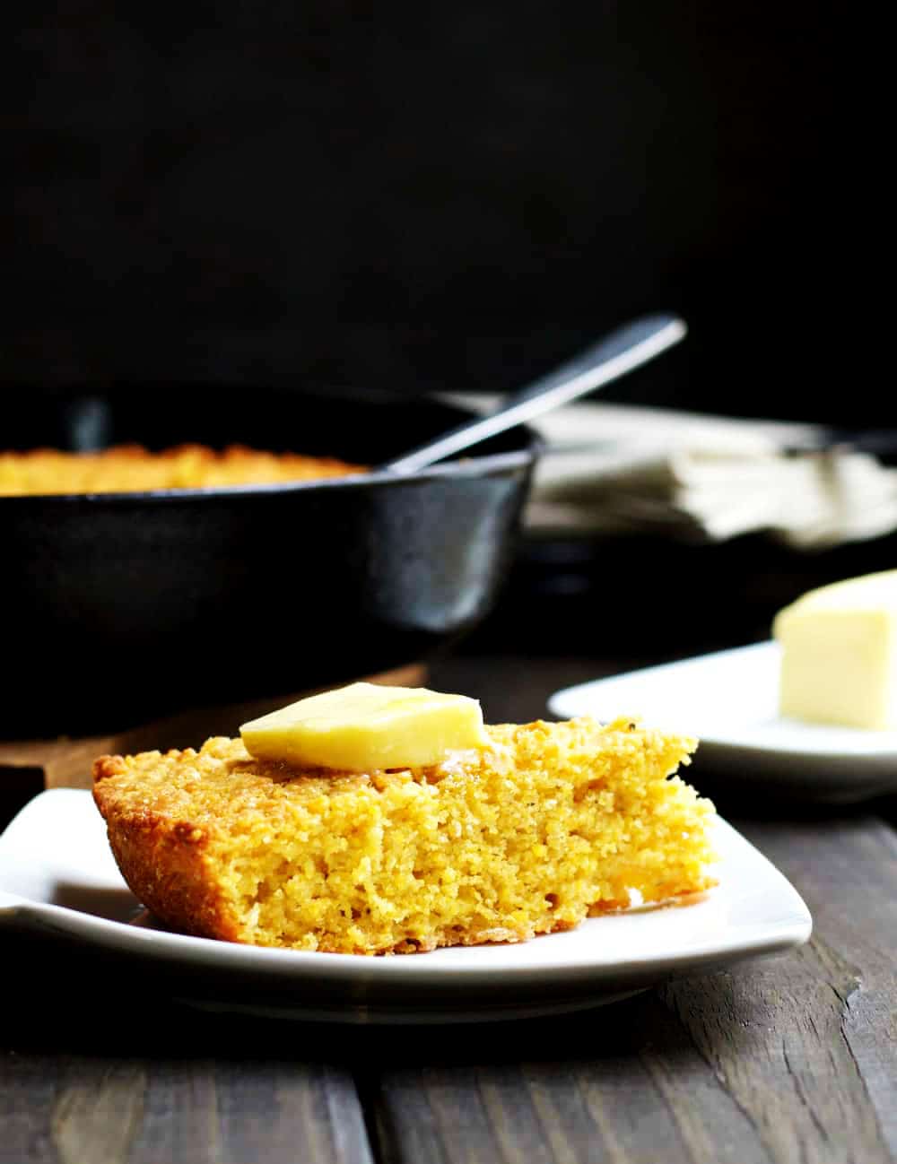 Skillet-Cornbread-served-with-butter on a white plate