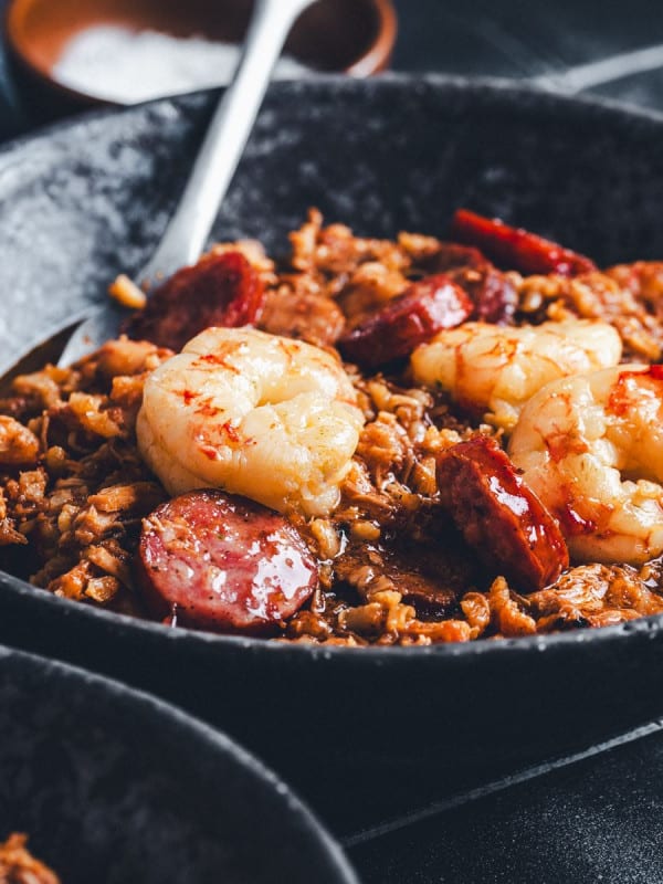 Jambalaya served in a black ceramic bowl and photographed at an angle.