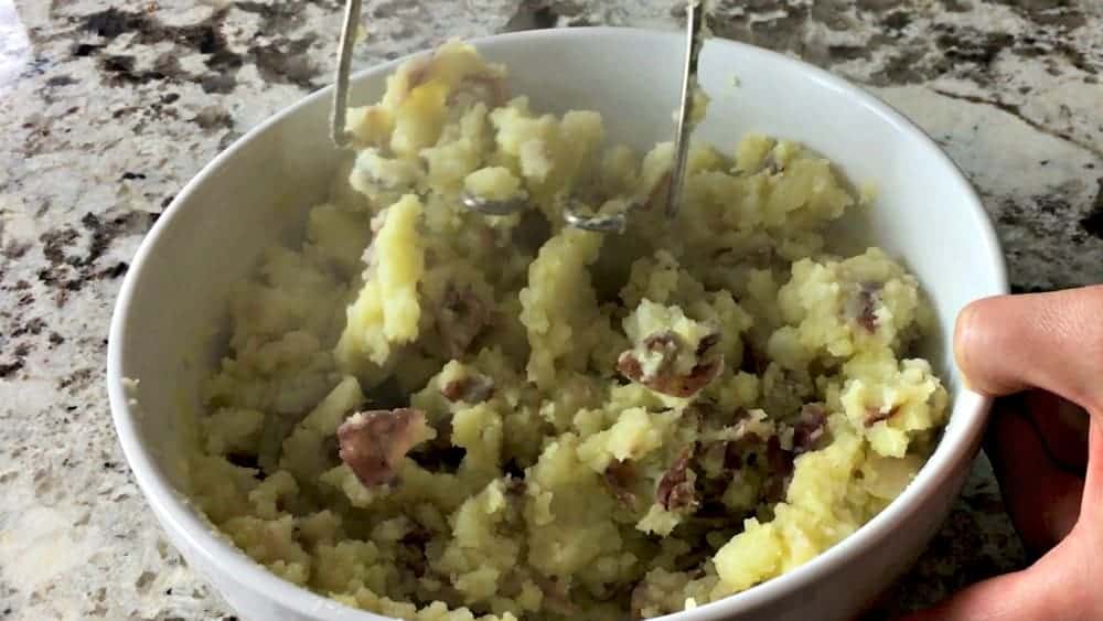 Mashing red potatoes with Olive Oil Mixture