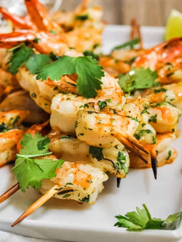 Spicy Grilled Shrimp served on a white platter with lime wedges.