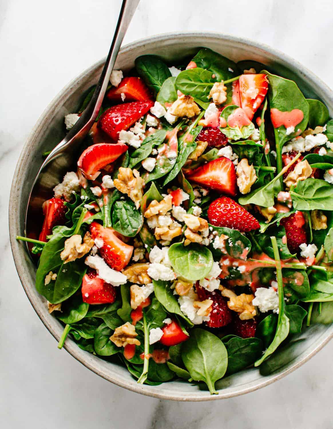 Spinach Strawberry Walnut Salad served in a light gray ceramic bowl