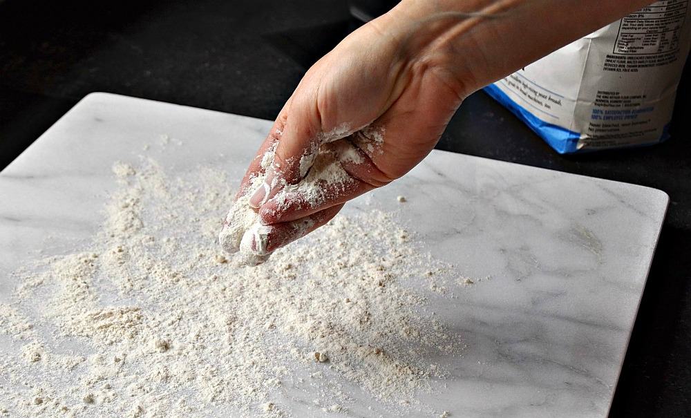 Sprinkling Flour on a Marble Pastry Board