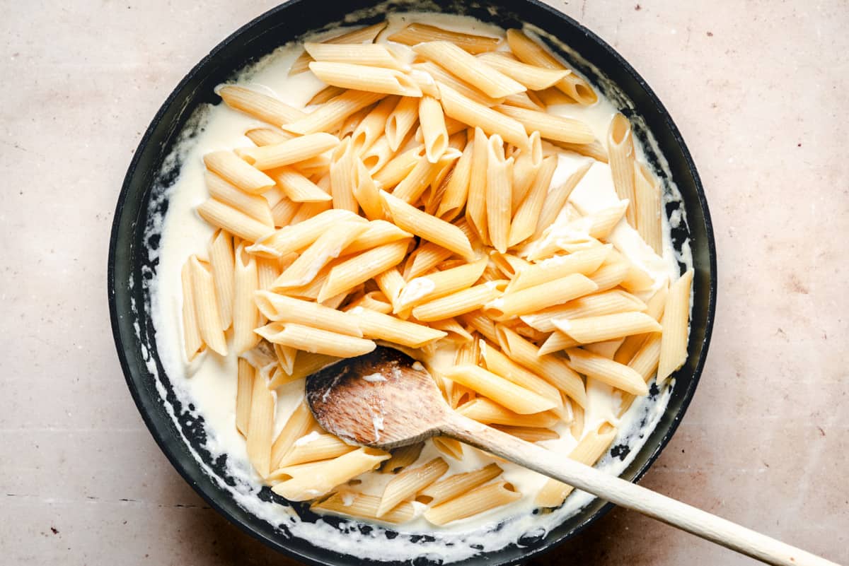 cooked pasta added to sauce in skillet.