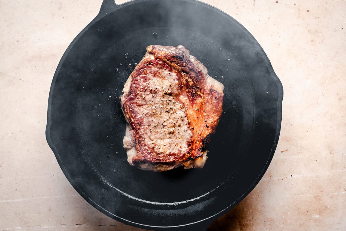 searing steak in cast iron skillet.