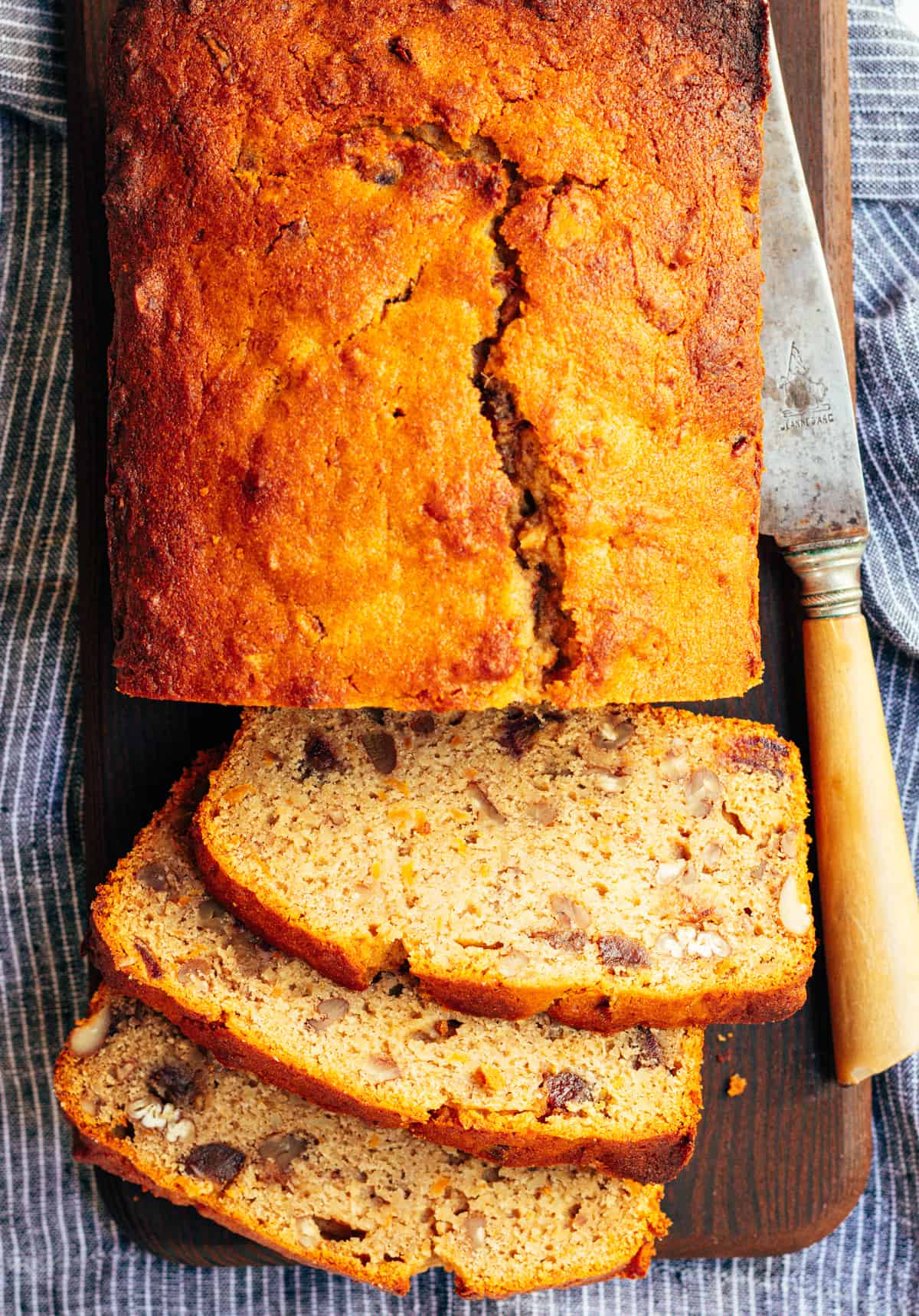 Sweet Potato Bread loaf and three slices on a cutting board with a knife.