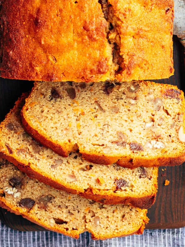 Sweet Potato Bread loaf and three slices on a cutting board with a knife.