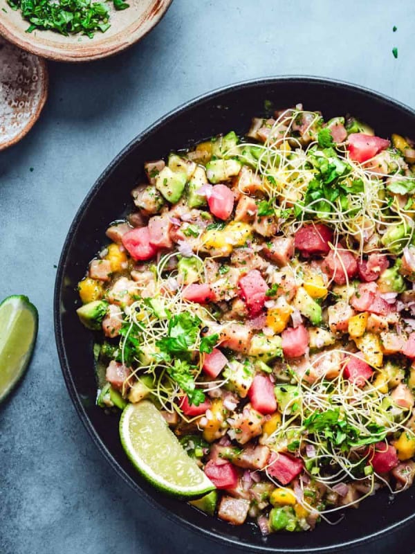 Tuna Ceviche served in a black bowl and photographed from overhead.