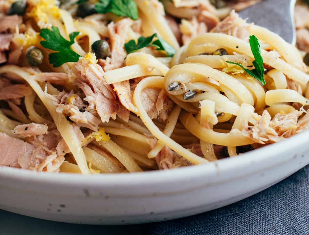 Tuna pasta swirled on a fork in a bowl.