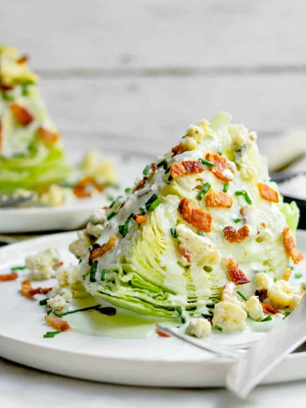 Wedge Salad served on white plates with knife and fork.