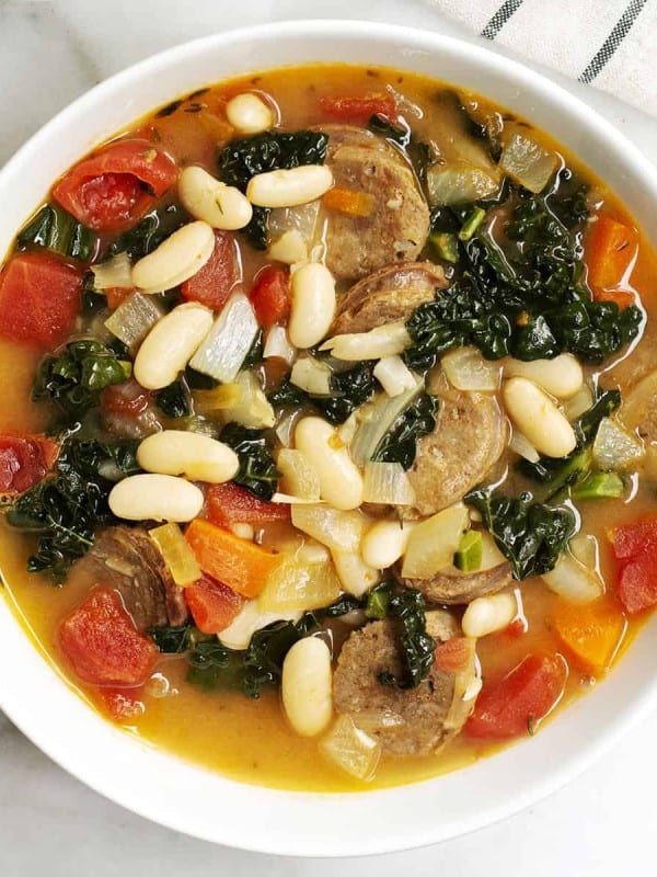 White Bean Sausage and Kale Soup served in a white bowl