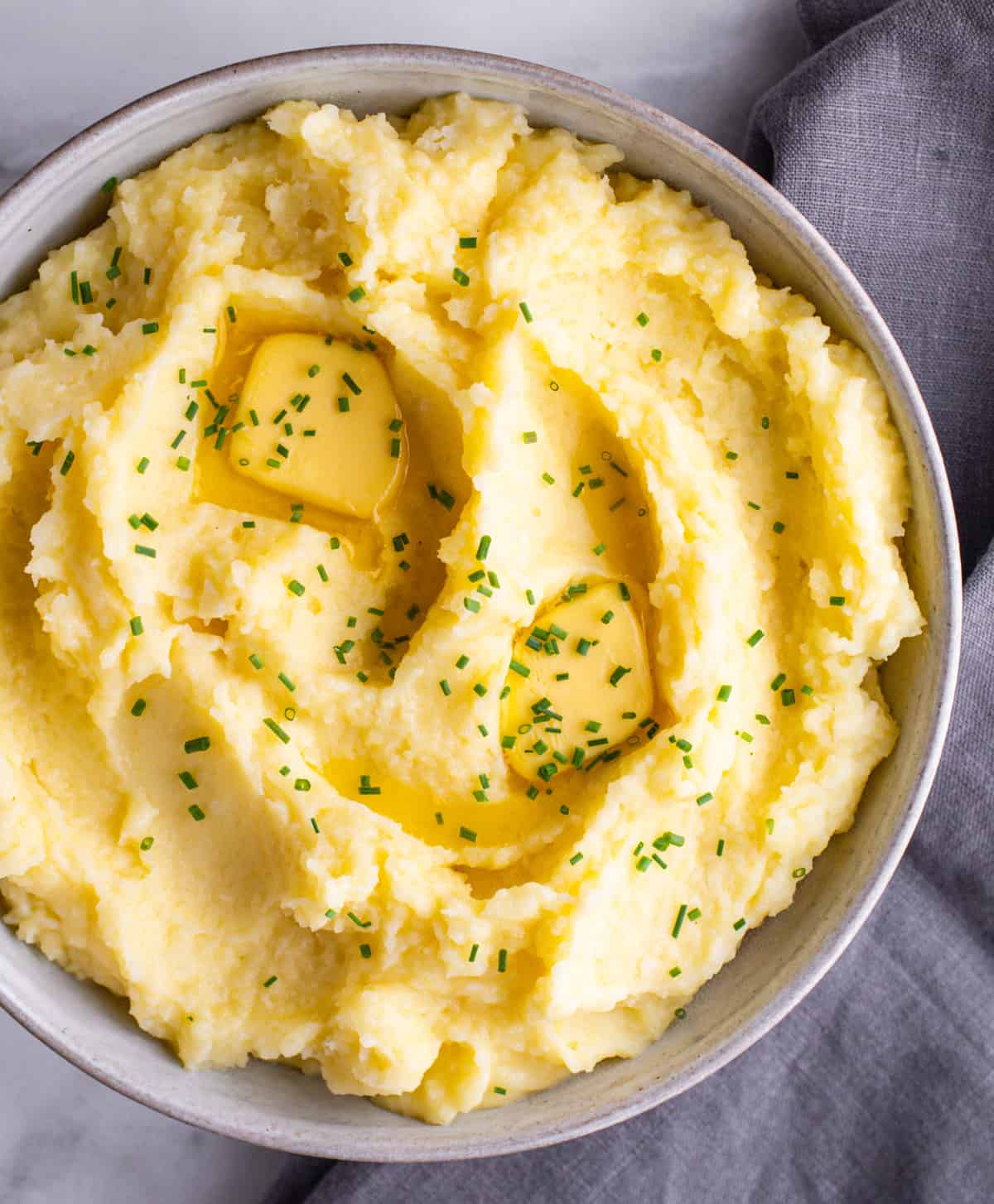 Yukon Gold Mashed Potatoes served in a ceramic bowl.