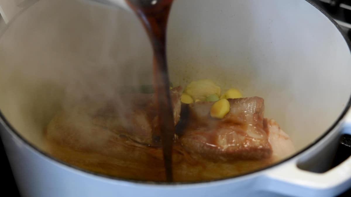 adding braising liquid to pot