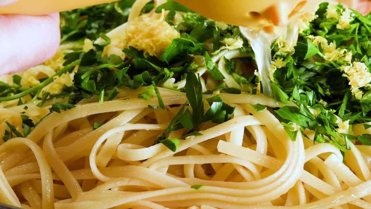 adding pasta parsley lemon zest and juice to skillet