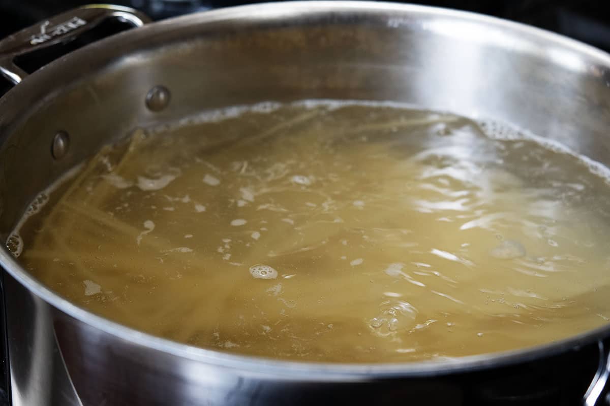 boiling dry spaghetti noodles in a stainless steel pot of boiling water