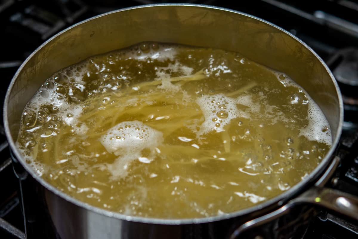 boiling linguine in a stainless steel saucepan.