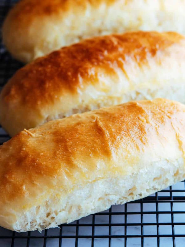 brioche hot dog buns on a metal cooling rack