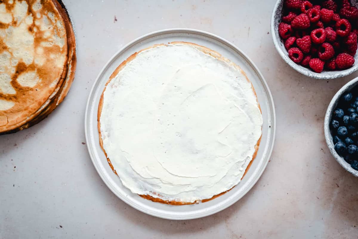 crepe spread to edges with whipped cream frosting.