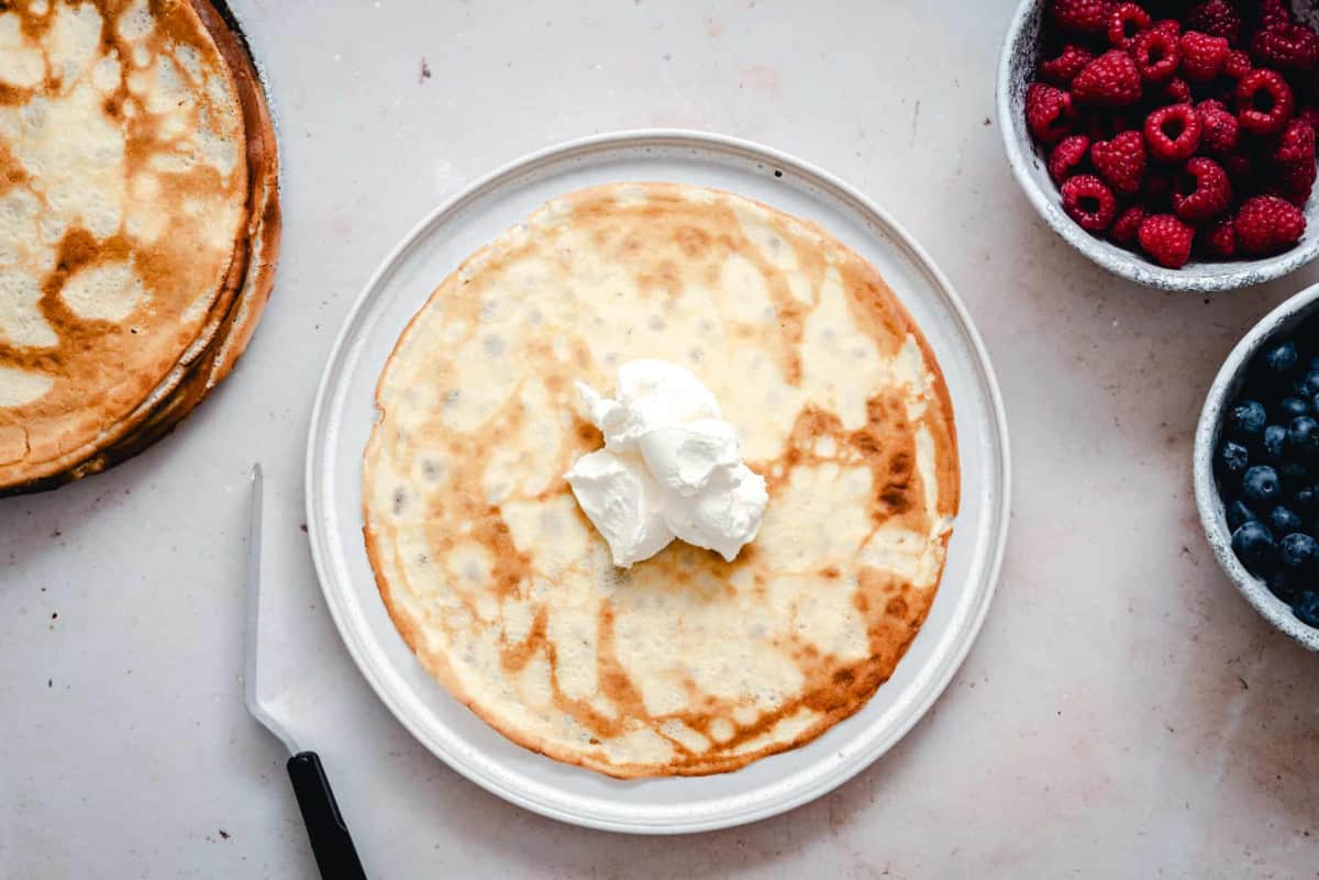 crepe with stabilized whipped cream frosting on top ready to spread.