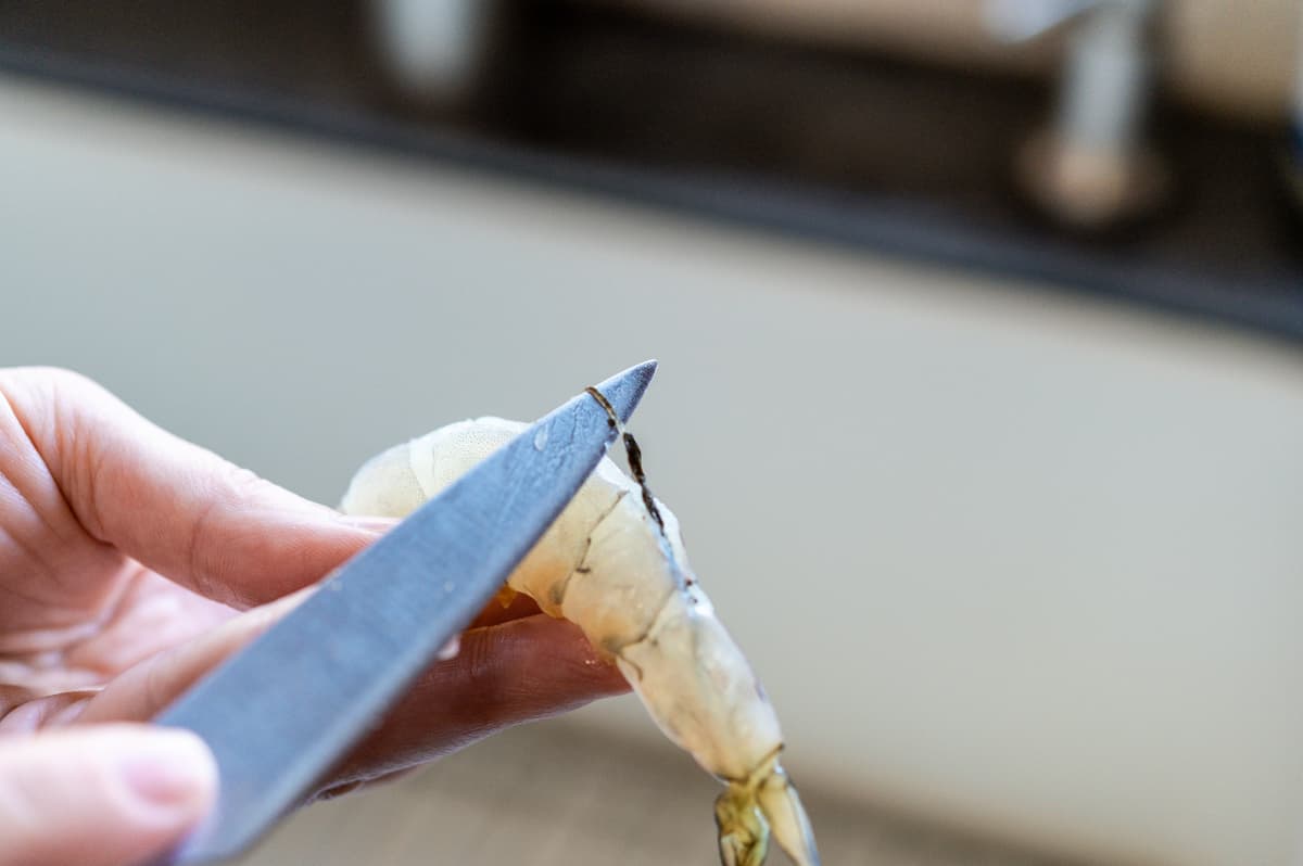 deveining raw shrimp with the tip of a paring knife.