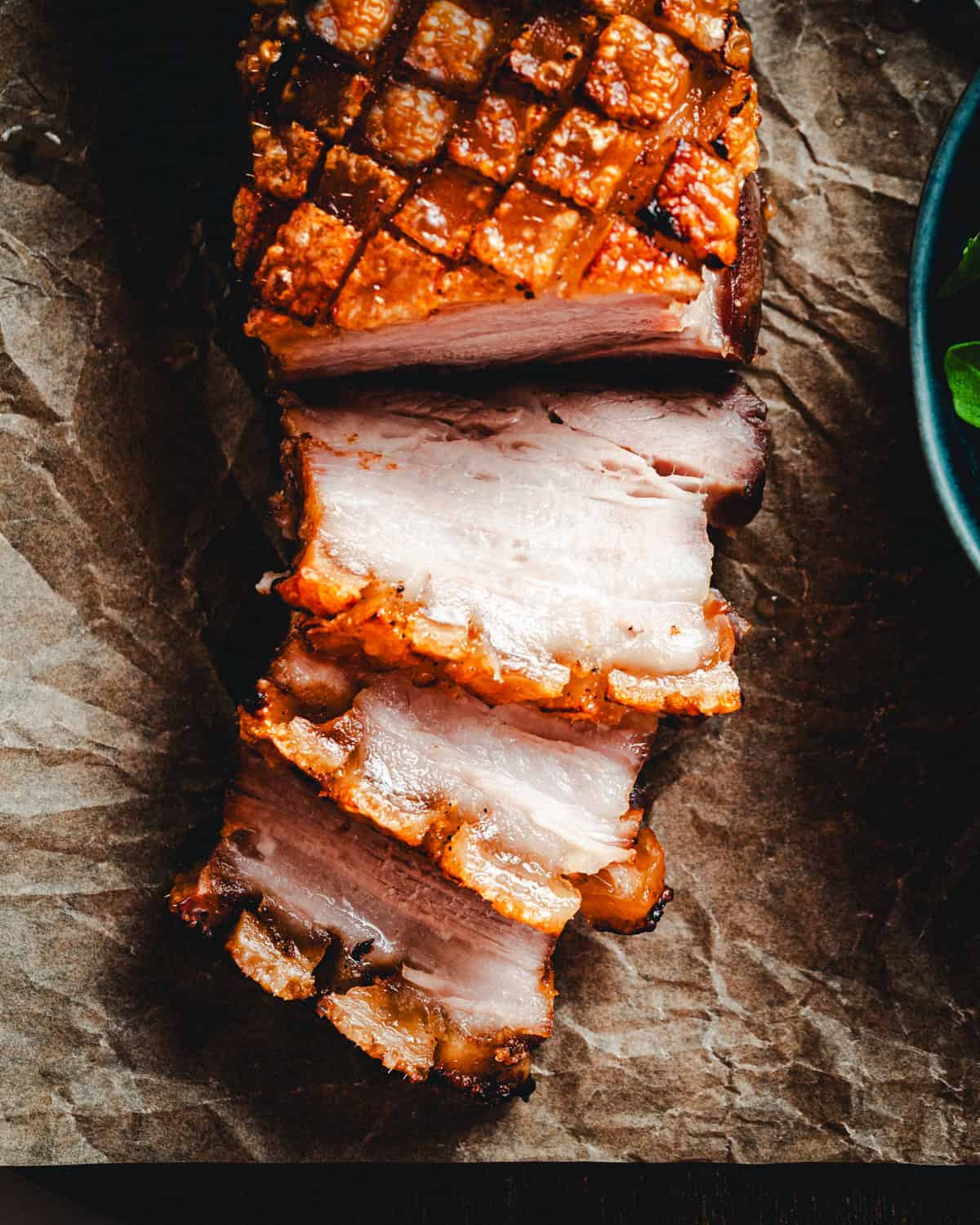 Closeup overhead view of skin on pork belly fresh from the oven with crispy skin.