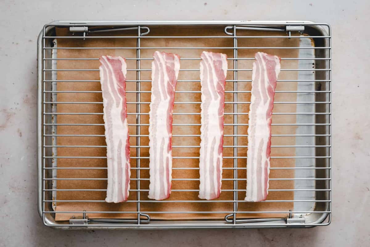 partially cooking bacon on rack in baking sheet.