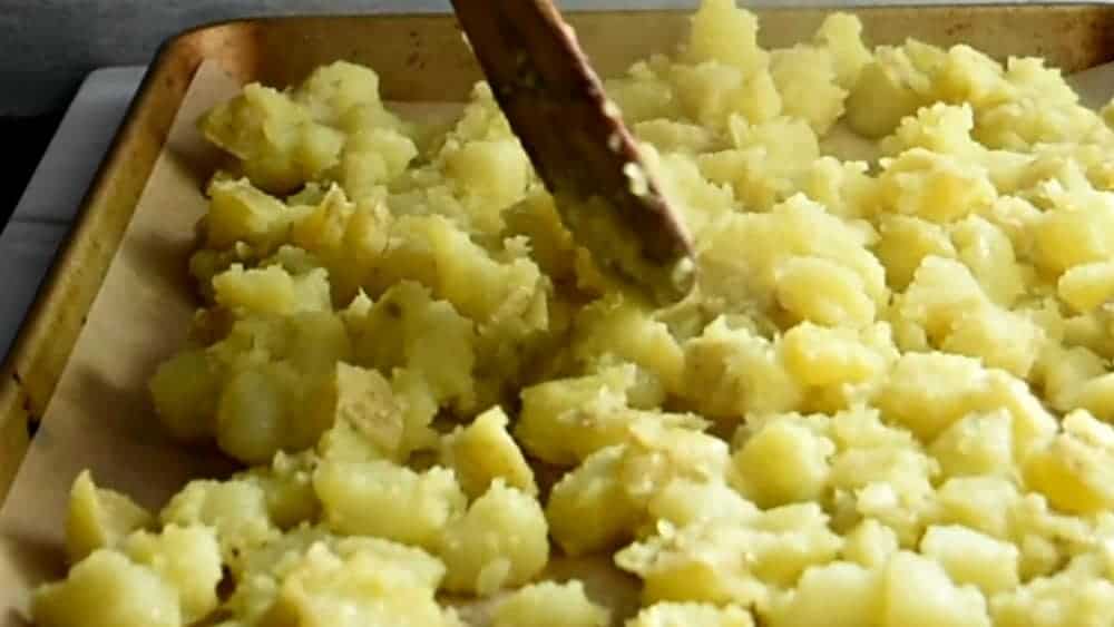 potatoes spread in a single layer on a prepared baking sheet