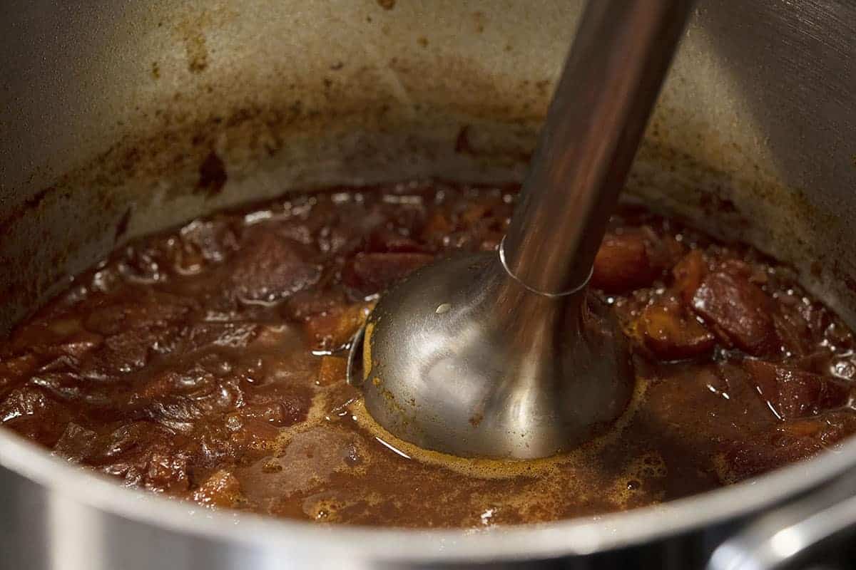 pureeing part of sauce with immersion blender