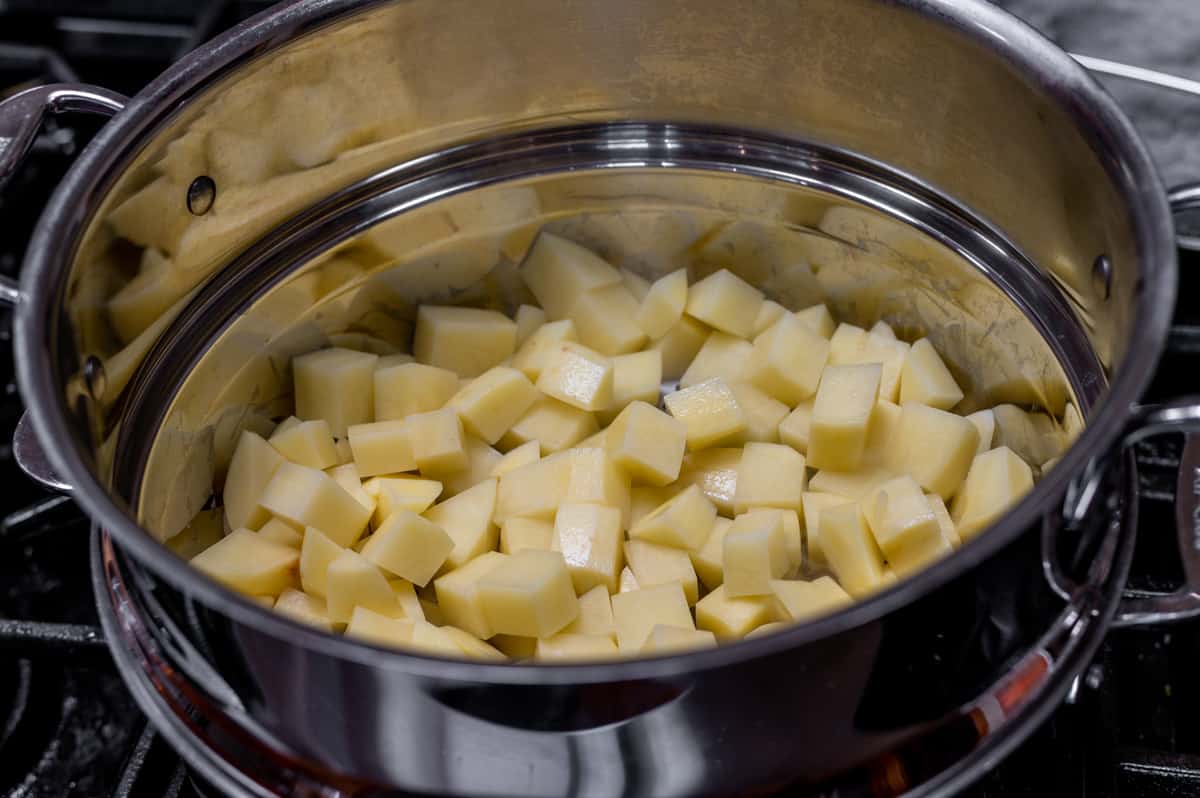 raw cubed yukon gold potatoes in steamer basket.