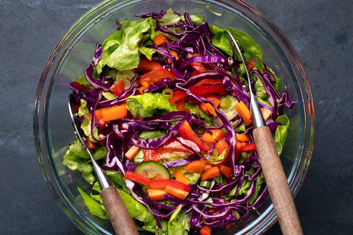 salad ingredients mixed together in a glass bowl.