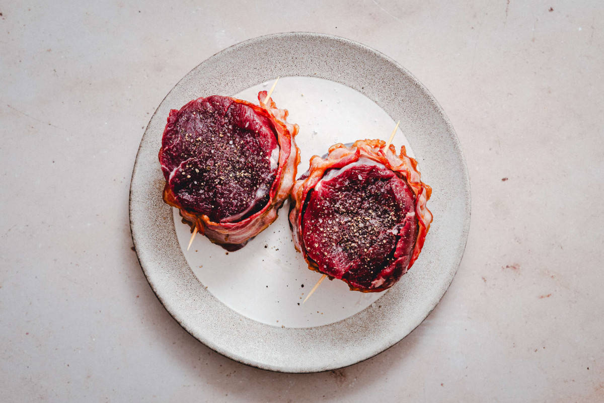 seasoned filet mignon steaks wrapped in partially cooked bacon.