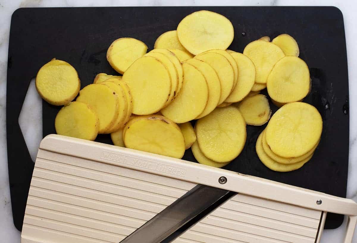 sliced potatoes on a black cutting board