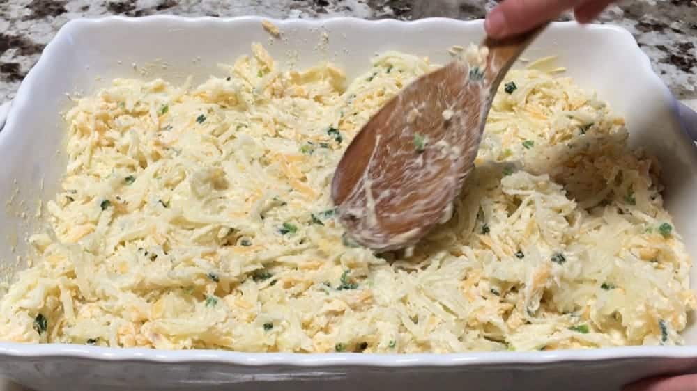 spreading potato and cheese mixture into baking dish