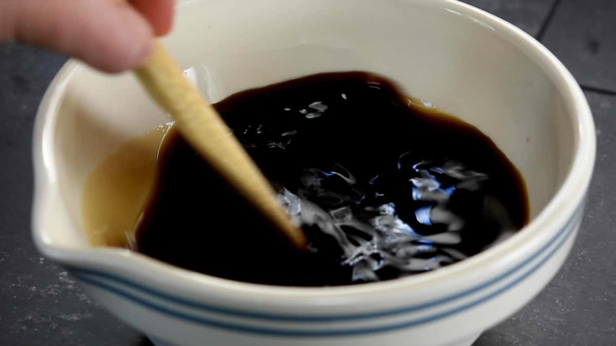 stirring braising sauce ingredients together in a ceramic bowl